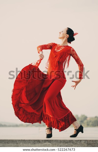 Flamenco dancer Spain womans in a long red dress\
dancing outside