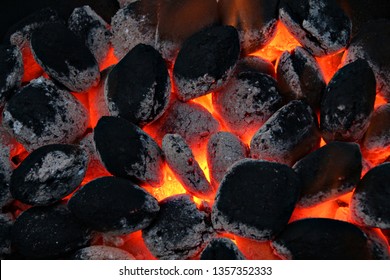 Flames and coals of a fire burning at night. Background of hot coals. - Powered by Shutterstock