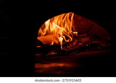 Flames flicker inside a rustic stone fireplace, showcasing burning logs and glowing embers, creating a warm and inviting atmosphere