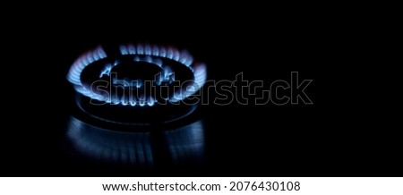 Flames of gas stove over dark background, panoramic layout with space for text