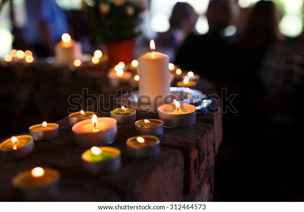 Flaming candles at\
the funeral ceremony\
indoor