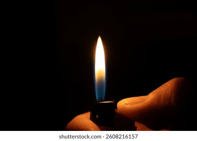 A flaming lighter in hand amidst the darkness