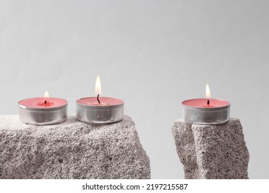 Flaming scented tea candles on stone. Gray background. Minimal concept. - Powered by Shutterstock