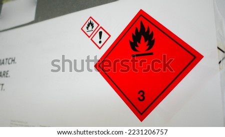 Flammable, acid, volatile, warning labels, mounted on hazardous chemical storage tanks in the warehouse of a chemical industrial factory plant. Waiting for delivery according to the user's order. 