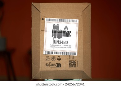 A flammable lithium battery is shipped in an envelope with a danger label. The label warns of the fire risk and shows the UN3480 code for lithium batteries. The envelope is sealed.