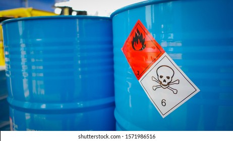 Flammable sign and dangerous sine on blue barrel tank in the storage yard of a chemical factory
