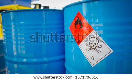 Flammable sign and dangerous sine on blue barrel tank in the storage yard of a chemical factory