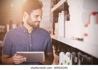 flare against male hairdresser using digital tablet - Powered by Shutterstock