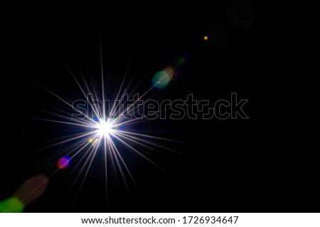 Flare light. Lens sunlight flash effect on black background. Sun shine ray star spot glow. Easy to add as overlay or screen filter over photos