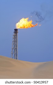 A Flare Stack Burning Off Excess Gas At An Oil Refinery In The Desert