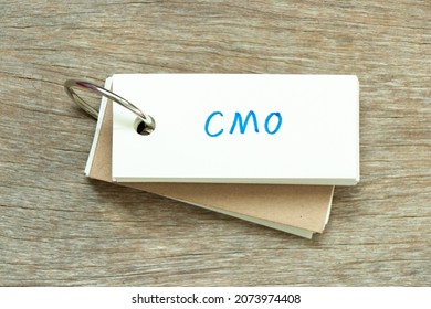 Flash Card With Handwriting Word CMO (Abbreviation Of Chief Marketing Officer, Contract Manufacturing Organization) On Wood Background