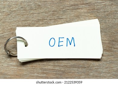 Flash card with handwriting word OEM (Abbreviation of Original Equipment Manufacturer) on wood background