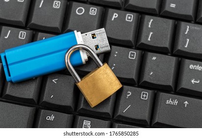 Flash drive with padlock on the laptop keyboard. 