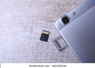 Flash memory data storage concept : A tray with a micro SD card on white background. A memory card is used for storing digital information in portable electronic devices e.g mobile phone, tablets
