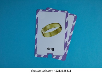 Flashcard With Photo Of Golden Yellow Ring Placed On Blue Background.