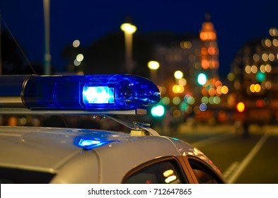 A flasher on the roof of a police car. Police. Background - city lights.