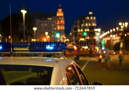 A flasher on the roof of a police car. Police. Background - city lights.