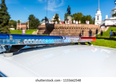 Flashing Light On A Police Car In A City Interior Near A Monument