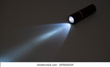 Flashlight and a beam of light in the dark. Flashlight ray in the darkness. Torchlight in the darkness