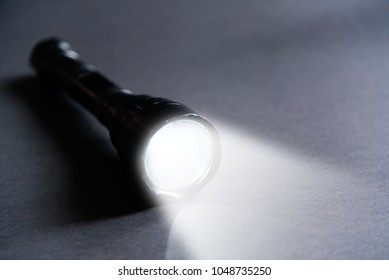 Flashlight and beam of light on a dark background