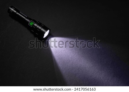 Flashlight and beam of light on a dark background,