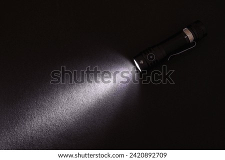 Flashlight and beam of light on a dark background,