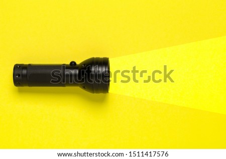 Flashlight or torch lighting up yellow background - minimal concept for internet search or direction finding