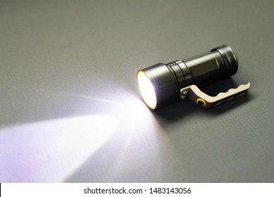 Flashlight Or Torch On A Grey Background.Today, Flashlights Use Mostly Incandescent Lamps Or Light-emitting Diodes And Run On Disposable Or Rechargeable Batteries.