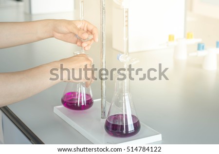 Flask and burette in scientist hand,lab