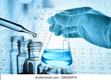 Flask in scientist hand with dropping liquid to test tube