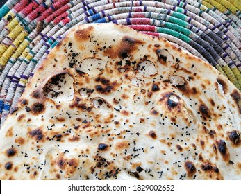 Flat bread (Arabic Yemeni middle eastern traditional cuisine) on colorful traditional round mat. - Shutterstock ID 1829002652