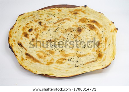Flat bread (Arabic Yemeni middle eastern traditional cuisine) on colorful traditional round mat.