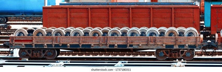 Flat Car Loaded With New Spare Parts For Axle Bogie, Railway Wheels For Locomotives Or Train Cars. Freight Car On Rails. Train Wheels, Wagon Axle. Supply Of Spare Wheels For Trains