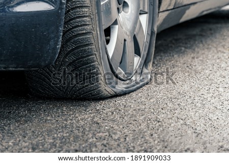 flat car tire close up, punctured wheel