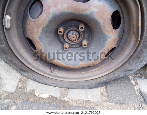 A flat car tire. Flat\
tire close up.