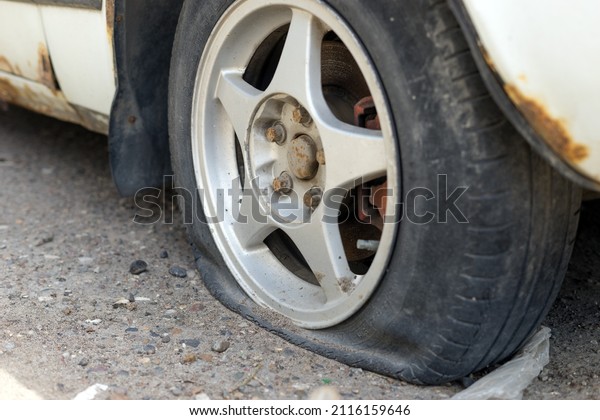 Flat car tire on the\
road in the city.
