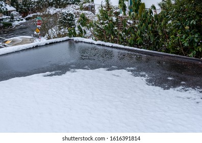 Flat Carport Roof Covered In Snow, Slush, Ice, And Water, With Clogged Downspout Drain, Residential Neighborhood
