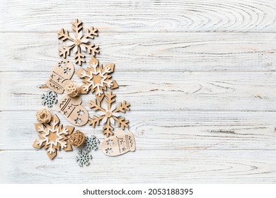 Flat composition with a Christmas tree made of different festive items, snowflakes, gifts, sweets on a white background. Copy space.
