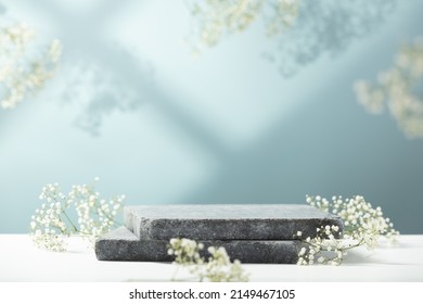 Flat granite pedestal and white flowers on blue background. Stone stand for natural design concept. Horizontal image, center composition, hard light, front view - Shutterstock ID 2149467105