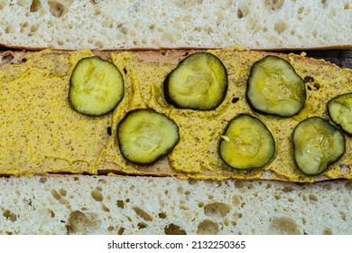 Flat Lay Above View Of White Bread Baguette Halves Spread With Mustard And Topped With Pickles Sandwich Making