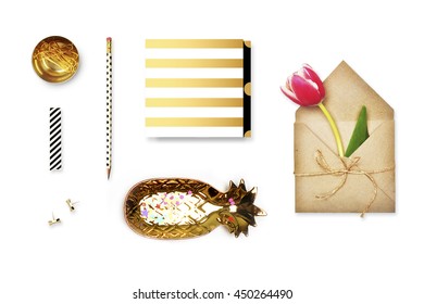 Flat lay. Accessories on the table, woman desk top. View top table, background mock up. Gold stationery,gold pineapple, pencil, flower in envelope, gold pattern.