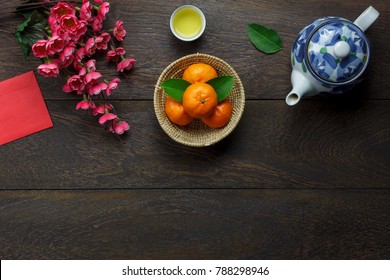 Flat lay aerial image of accessories Lunar New Year & Chinese New Year holiday background concept.Space for mock up & template.Top view objects on modern rustic brown wooden at home office desk.