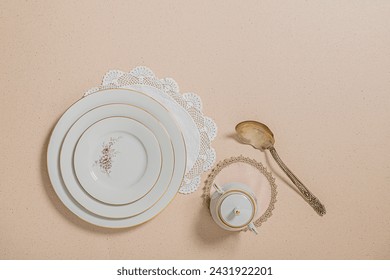 Flat lay of antique ceramic dinnerware set with vintage spoon and negative space
