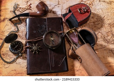 Flat Lay Antique Compass Pocket Watch And Leather Journal On Old World Map