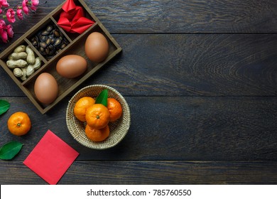 Flat lay of arrangement Chinese new year & lunar background holiday concept. Orange and essential food on modern rustic wooden at home office desk.Free space for creative design text and wording.
