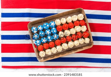 Flat lay. Arranging mini vanilla cupcakes in the shape of the American flag.