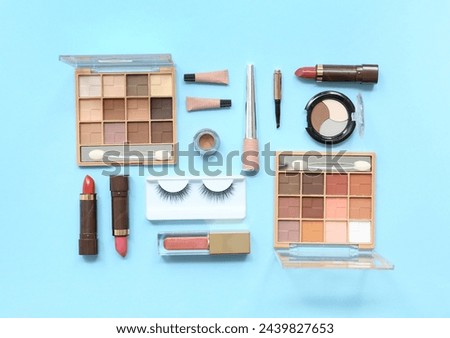 Flat lay of assorted makeup products on blue background, beauty and cosmetics industry, fashion and personal care