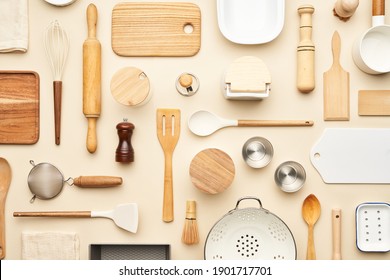 Flat lay of assorted wooden and ceramic utensils and containers placed on beige background - Shutterstock ID 1901717701