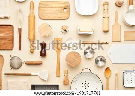 Flat lay of assorted wooden and ceramic utensils and containers placed on beige background