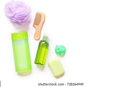 Flat Lay Baby Bath Products. Bathroom Items. Green Shampoo Bottle, Purple Sponge Puff, Wooden Comb, Essential Oil, Baby Soap And Toy Rubber Frog. Mockup, Free Space For Text